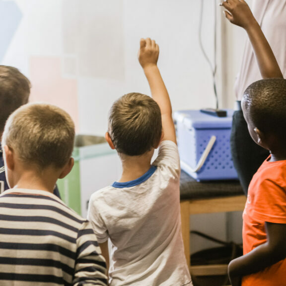 teaching-children-raising-hands-in-classroom